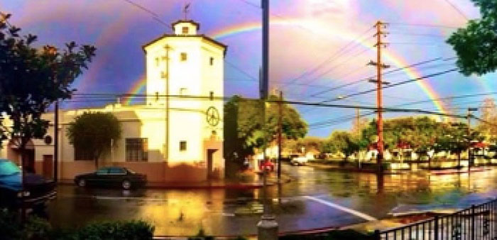 la casa building with a rainbow behind it